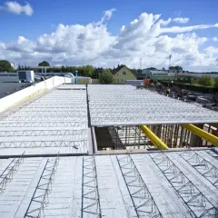 Budowa nowoczesnych budynków z wykorzystaniem różnych rodzajów stropów. Widoczne elementy konstrukcyjne stropów prefabrykowanych.
