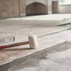 Młotek gumowy i poziomica na świeżo ułożonych płytkach. Czekamy, aż beton wyschnie, by dokończyć remont.