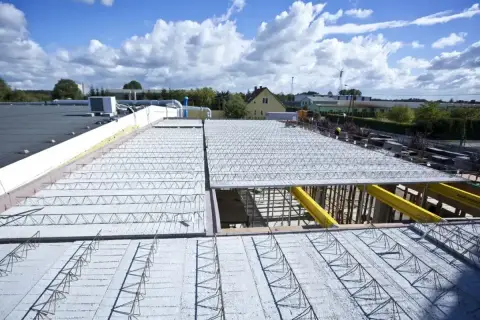 Budowa nowoczesnych budynków z wykorzystaniem różnych rodzajów stropów. Widoczne elementy konstrukcyjne stropów prefabrykowanych.
