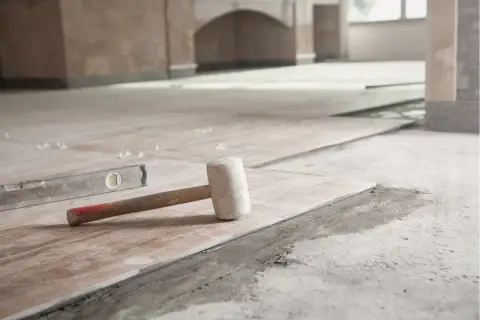 Młotek gumowy i poziomica na świeżo ułożonych płytkach. Czekamy, aż beton wyschnie, by dokończyć remont.