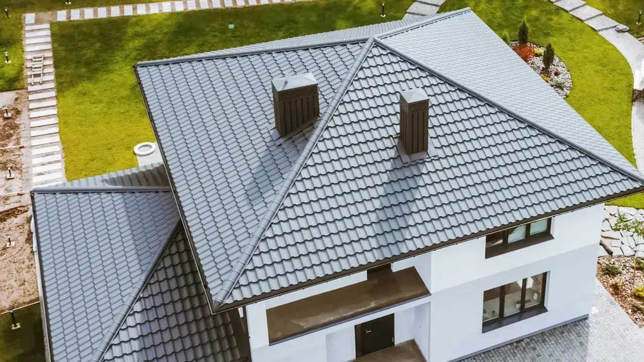 Nowy dach dwuspadowy 200m2 w nowoczesnym stylu. Szare dachówki, dwa kominy. Wokół zadbany ogród.