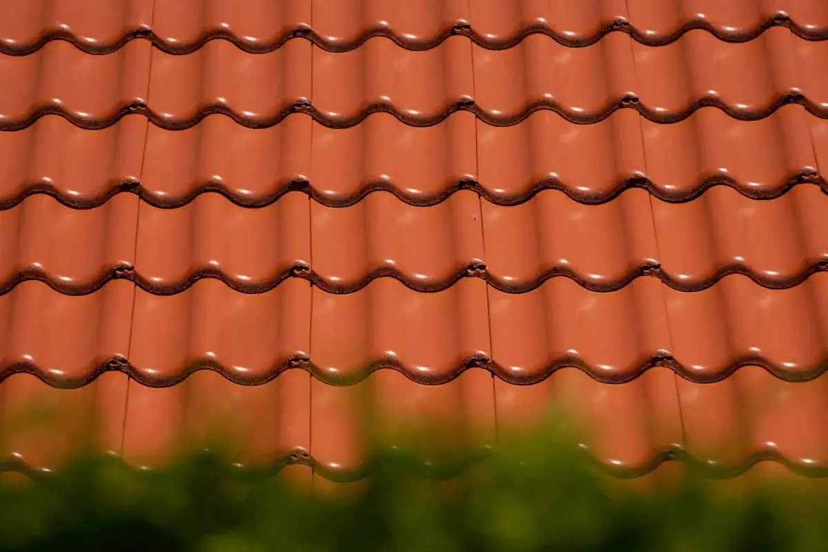 Czerwone, faliste dachówki ceramiczne tworzą gładką, jednolitą powierzchnię. Różne rodzaje dachówek mogą nadać budynkowi unikalny charakter.